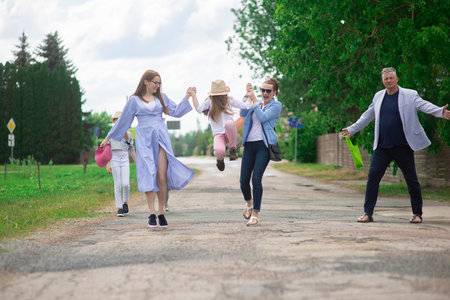 Group of happy family people walking down the city street on a sunny summer dayの写真素材