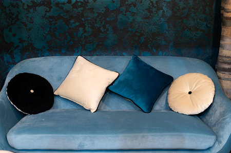 Round and square decorative pillows on a cozy blue sofa, home decorの写真素材
