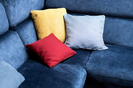 Closeup view of multicolor pillows on blue couchの写真素材