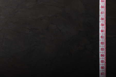 Measuring tape on dark background, fitness and diet concept, background with copy spaceの写真素材