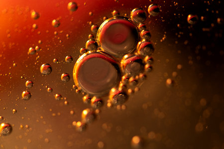 Oil in water, abstract background in golden and red color tonesの写真素材