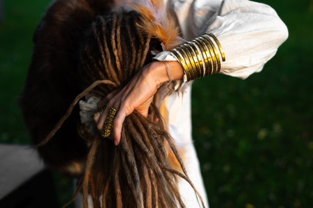 A woman arranges her dreadlocks