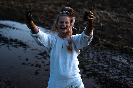 Happy woman with dirty black hands on a muddy field, joyful emotions in monochromeの写真素材