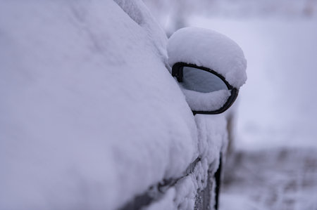 Car rearview mirror with snow cap after a snowstorm in winter timeの写真素材