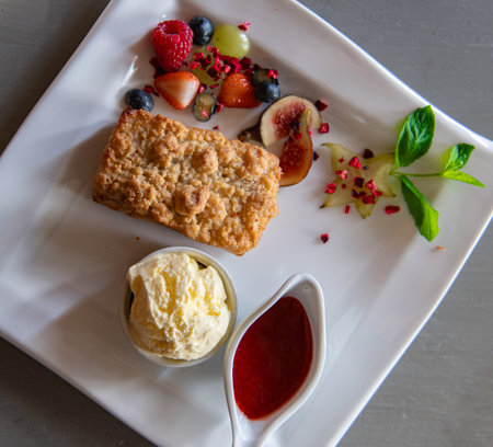 Top view on apple cake with homemade ice cream and strawberry sauceの写真素材