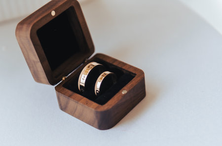 Gold wedding rings displayed in an open wooden ring box during a wedding moment in Latvia.の写真素材