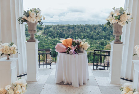 Wedding table with multiple flower bouquets arranged on elegant terrace with forest landscape view in Latvia.の写真素材
