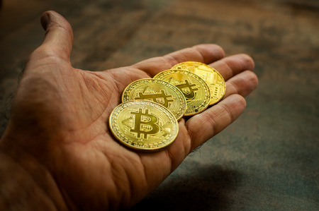 Hand holding Bitcoin coinsの写真素材