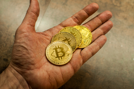 Hand holding Bitcoin coinsの写真素材