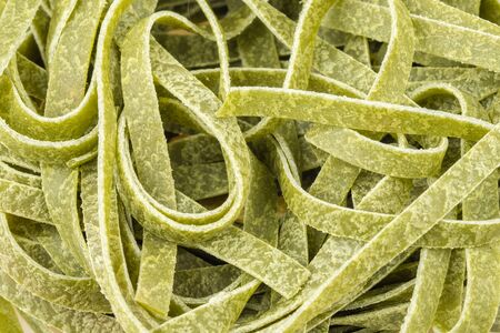 Uncooked green tagliatelle pasta, one nest, macro close upの写真素材