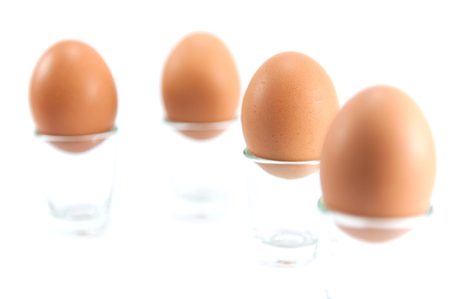Brown chicken eggs in glass on white background.の写真素材