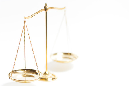 Close up of gold brass balance scale, Sign of justice isolated on white backgroundの写真素材