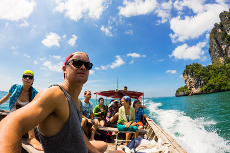 KRABI, THAILAND, 30 OCTOBER 2012 : Company of young people going to adventure to Tonsai and Railay beaches at Krabi Province by traditional thai longtail boat.のeditorial素材