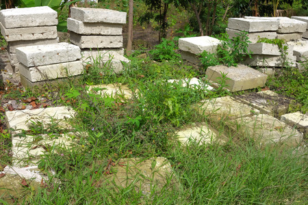 Piles of square concrete blocks overgrown with grassの写真素材