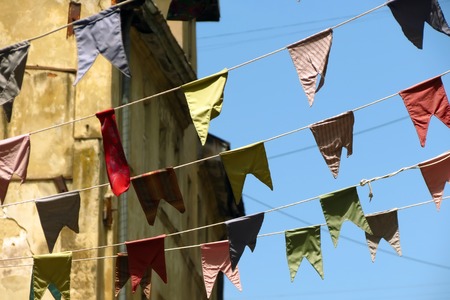 Bunting, colorful party flags against old building