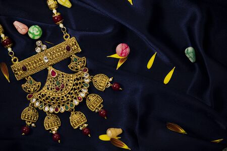 Golden Jaipuri Choker set necklace isolated on silky dark blue cloth backgroundの写真素材