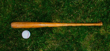 Baseball bat aand ball on grass backgroundの写真素材