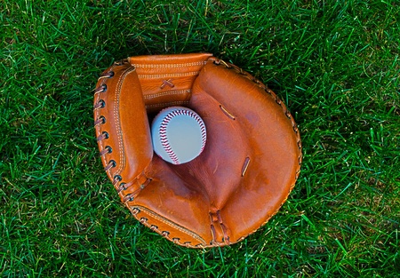 Catchers glove and ball on grass backgroundの写真素材
