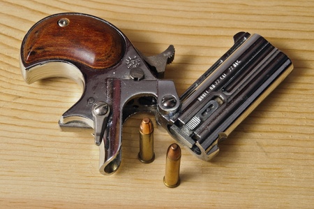 silver 22 magnum derringer on wood backgroundの写真素材
