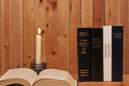 books  and candle on wood background