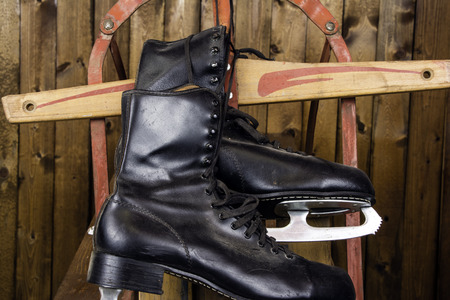 Vintage ice skates and old sled on rustic backgroundの写真素材