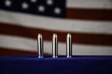three 357 magnum bullets in front of american flag