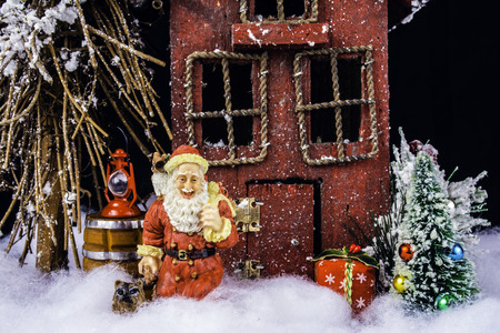 Santa and his dog in deep snow leaving gifts at rustic homeの写真素材