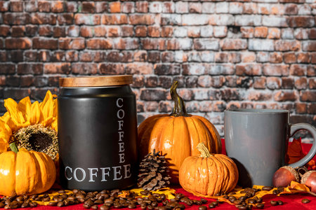 horizontal autumn scene with coffee canister and beans on red with pumpkins and sunflower with no peopleの写真素材