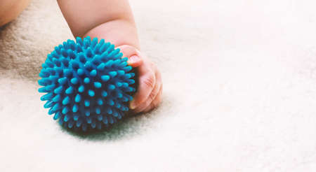Little baby hand holding a small blue ball.の写真素材