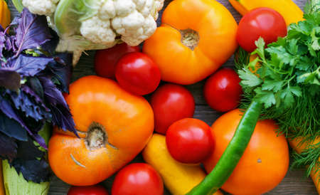 Colorful fresh vegetables background. Ripe multicolor vegetables close-up on wooden table. Red and...