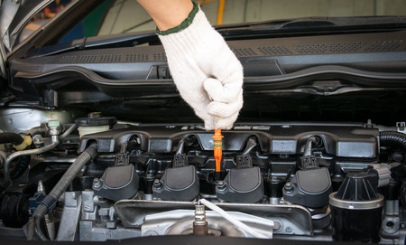 Man checking oil in his car using dipstickの写真素材