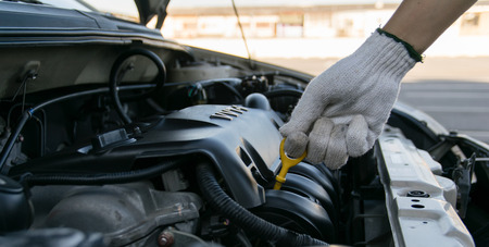 Man checking oil in his car using dipstickの写真素材