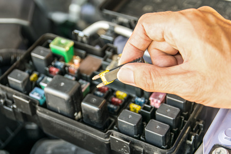 Auto mechanic checking a car fuseの写真素材