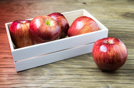 Apples in the box. Red apples on a wooden table.の写真素材
