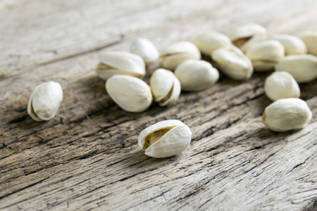 Pistachio nuts on wood background