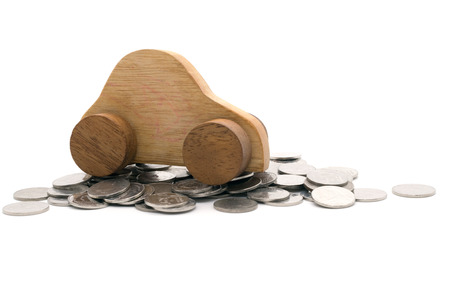 Wood car on a pile of coins on white backgroundの写真素材