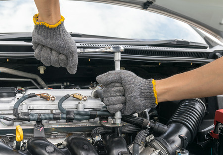 Hands of car mechanic in auto repair service.