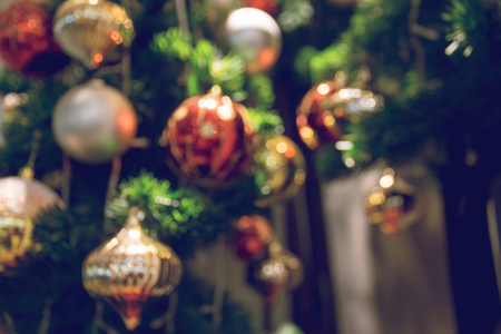 bauble hanging from a decorated Christmas tree. Blur and Retro filter effect.の写真素材