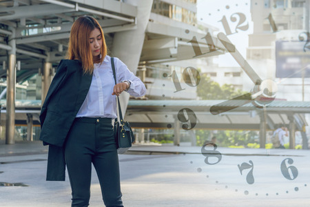 Young business woman checking the time on her watch.の写真素材