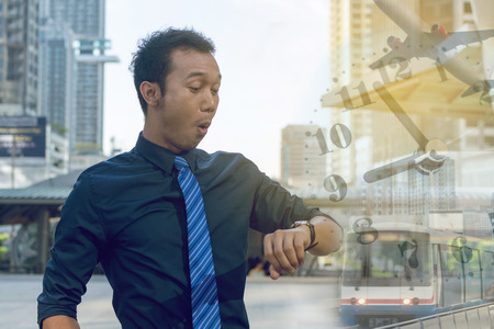 Young business man checking the time on his watch. time planes trainsの写真素材