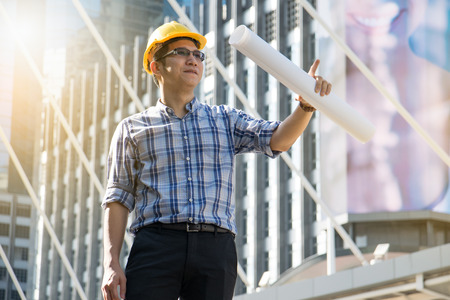 Foreman construction worker holding blueprint