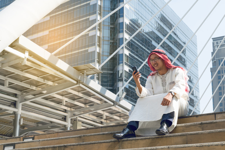Arab businessman messaging on a mobile phone in the cityの写真素材