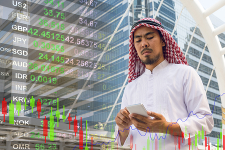 Arab businessman check graph on smartphone, finance conceptの写真素材