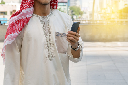 Arab businessman messaging on a mobile phone in the cityの写真素材