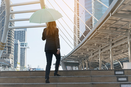 Businesswoman holding an umbrella in cityの写真素材