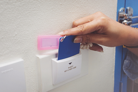 Asian women hand hold card for door access control scanning key card to lock and unlock door.