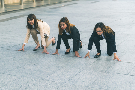 businesswomen at city standing in start positionの写真素材