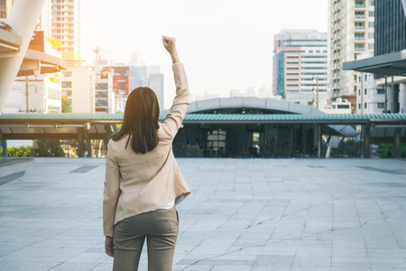 Winner woman celebrating success on city background.の写真素材