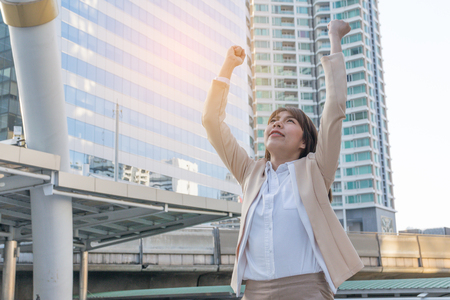 Winner woman celebrating success on city background.の写真素材
