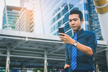 businessman in suit using smartphone at cityの写真素材